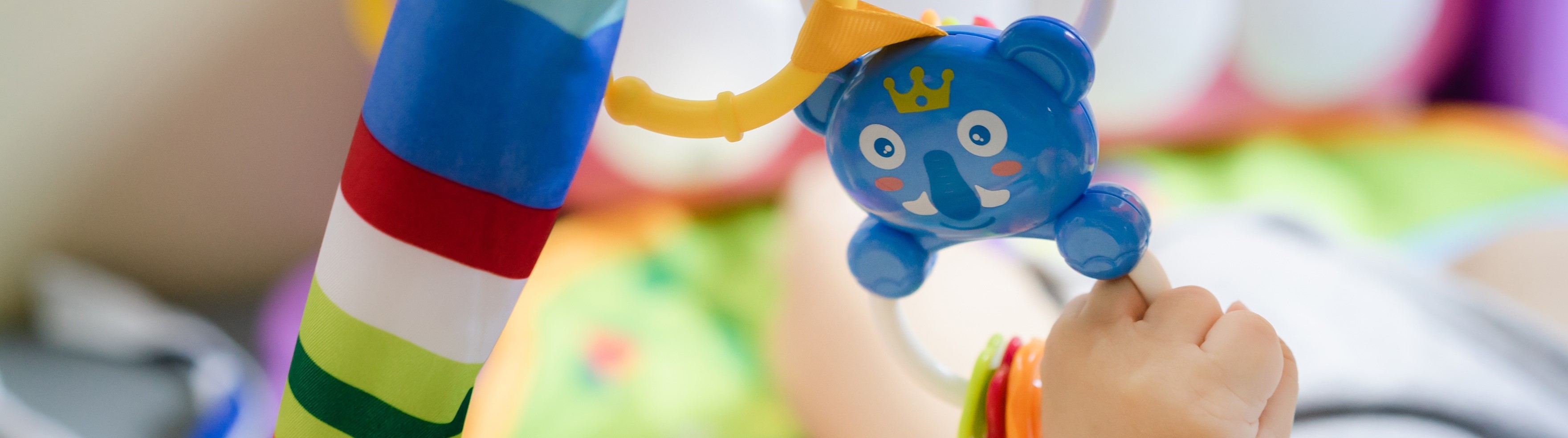 Picture of child's arm grabbing colourful hanging toy